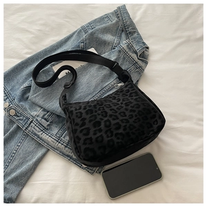 Detail of black leopard print canvas tote bag with adjustable strap on denim jacket