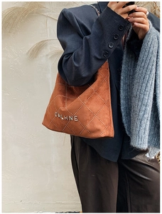 Detail of brown suede hobo bag with silver metallic studs and Calhne logo branding
