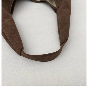 Close-up of durable brown faux suede texture and fine stitching on a vintage tote bag