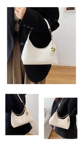 Detail van witte laksleutel hobo tas met fashion reliëf en goudkleurige metalen bedel