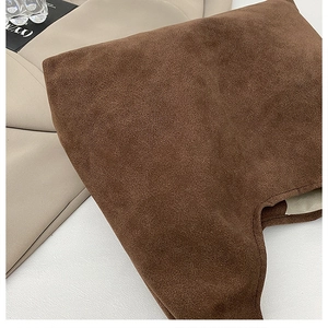 Close-up of deep brown suede texture showing premium matte finish and fine craftsmanship