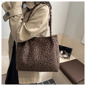 Close-up of leopard print tote bag with woven brown handle and plush texture detail