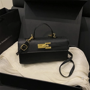 Black leather handbag with gold clasp in a luxury gift box with white satin lining