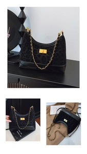 Detail of black leopard print crossbody bag with golden chain and metallic twist lock
