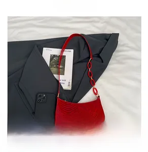 Close-up of red snakeskin texture handbag with link chain strap on stylish background