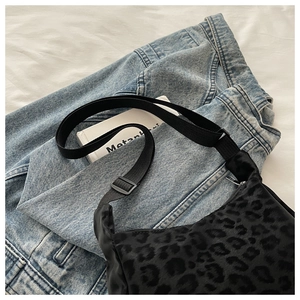 Close-up of leopard print crossbody bag with velvet texture and adjustable strap