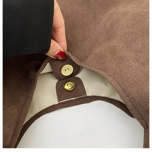 Detail of vintage brown suede tote bag with brass magnetic closure and white lining