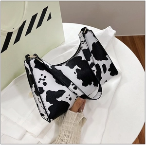 Detailed cow print hobo bag with smooth black zipper and integrated shoulder strap