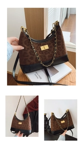 Detail of leopard print shoulder bag featuring gold chain strap and metal turn-lock closure