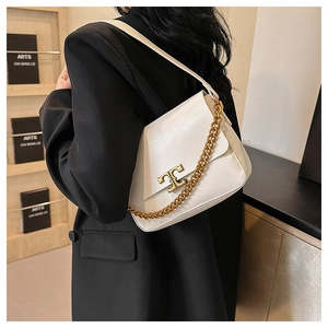 Detail of white leather shoulder bag featuring a gold chain strap and metal logo buckle