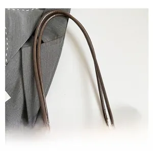 Detail of leopard print tote bag featuring brown slim handles and metal ring hardware