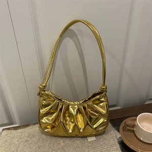 Borsa hobo a mezzaluna dorata metallizzata con nodo su sfondo in maglia bianco crema