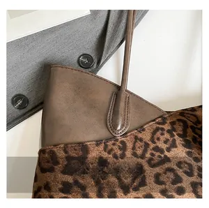 Detail of leopard print stitching and brown matte leather texture on retro tote bag
