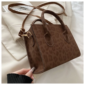 Dettaglio della borsa leopardata con trama in pelle scamosciata e fibbie in metallo dorato