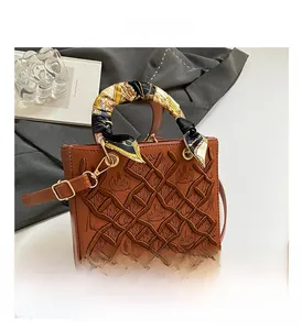 Dettaglio borsa tote marrone vintage con ricami e manico decorato con foulard di seta