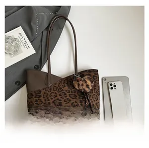Detailed leopard print tote bag with plush heart charm and dark brown leather stitching