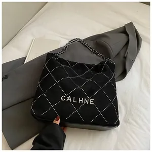 Detail of black quilted velvet bucket bag with sparkling diamond patterns and chain strap