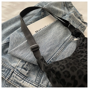 Close-up of black leopard print bag featuring soft texture and adjustable nylon strap