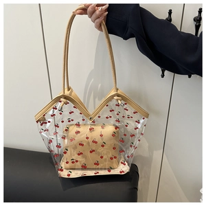 Dettaglio della borsa trasparente con ciliegie con pochette interna e manici gialli