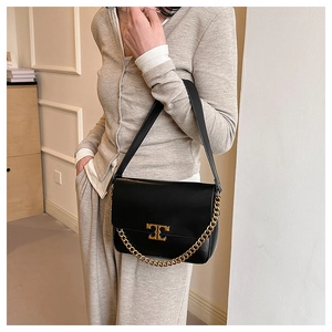 Fashionable black leather shoulder bag with gold chain and logo shown on model