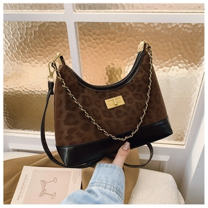 Detail of leopard print hobo bag showing gold turn-lock closure and metal chain strap