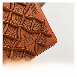 Dettaglio borsa in pelle sintetica marrone con ricamo floreale 3D spesso e finitura premium