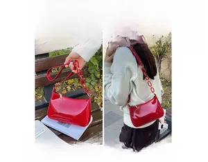Detail of red snake pattern faux leather shoulder bag with gold chain strap design