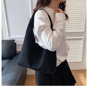 Detail of the minimalist black suede Hobo bag with large capacity and a sleek modern design