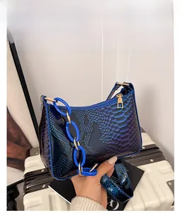 Detail view of the gradient blue-purple baguette bag with shiny crocodile texture and chain