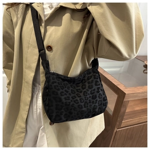 Detail of trendy leopard print hobo bag with adjustable strap worn on shoulder