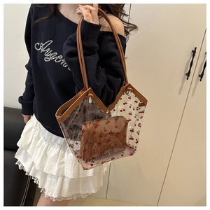 Detailed view of transparent PVC cherry print tote bag with inner pouch on shoulder