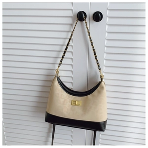 Detail of leopard print tote bag featuring beige canvas with black leather trim and gold lock