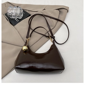 Détail du sac Hobo en cuir verni marron foncé avec gaufrage Fashion et breloque dorée