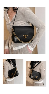 Detail of black flap bag with gold chain strap and metallic T logo on leather
