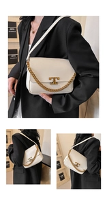 Detail of white leather shoulder bag with gold T-shaped metal clasp and chain strap