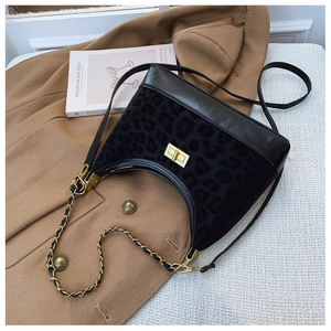 Detailed shot of leopard print shoulder bag featuring gold twist lock and chain strap