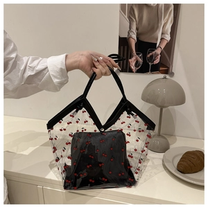 Dettaglio della borsa tote in PVC trasparente con stampa ciliegia e pochette nera interna
