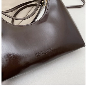 Détail du cuir brillant marron foncé avec lettrage FASHION embossé sur la surface