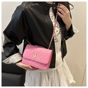 Detailed view of pink quilted handbag with gold chain strap and rotary lock buckle