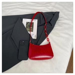 Close-up of red snake skin texture on underarm bag with thick chunky chain detail