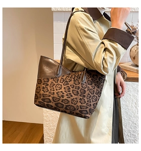 Leopard print tote bag with brown leather stitching shown on model shoulder