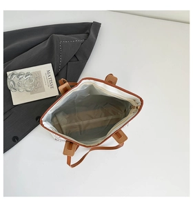 Detail der großen Canvas-Tasche mit rotem Buchstabendruck und geräumigem Innenfutter