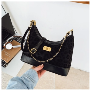 Detail of leopard print suede hobo bag with gold turn-lock and metal chain strap