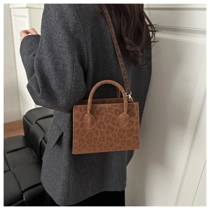 Detail of leopard print crossbody bag styled with a gray oversized blazer for a winter look