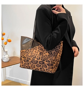 Detailed side view of large leopard print tote bag with brown leather handles