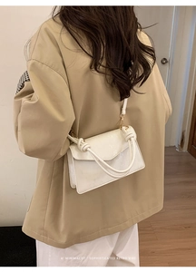White faux crocodile skin crossbody bag shown as a minimalist shoulder bag on a model