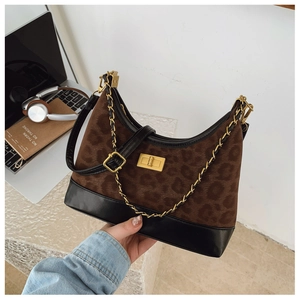 Detail shot of leopard print hobo bag with gold twist lock and woven chain strap