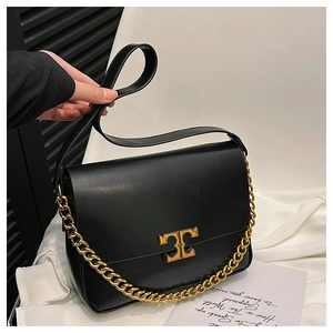 Close-up of black square shoulder bag featuring gold T-logo lock and chunky chain detail