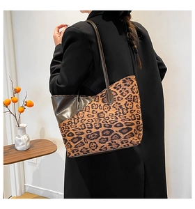 Detailed back view of a large leopard print tote bag with dark leather trim on a model