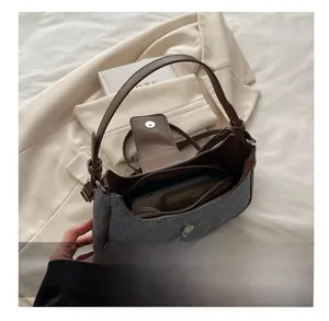 Interior view of grey felt underarm bag showing compartments and daily essentials